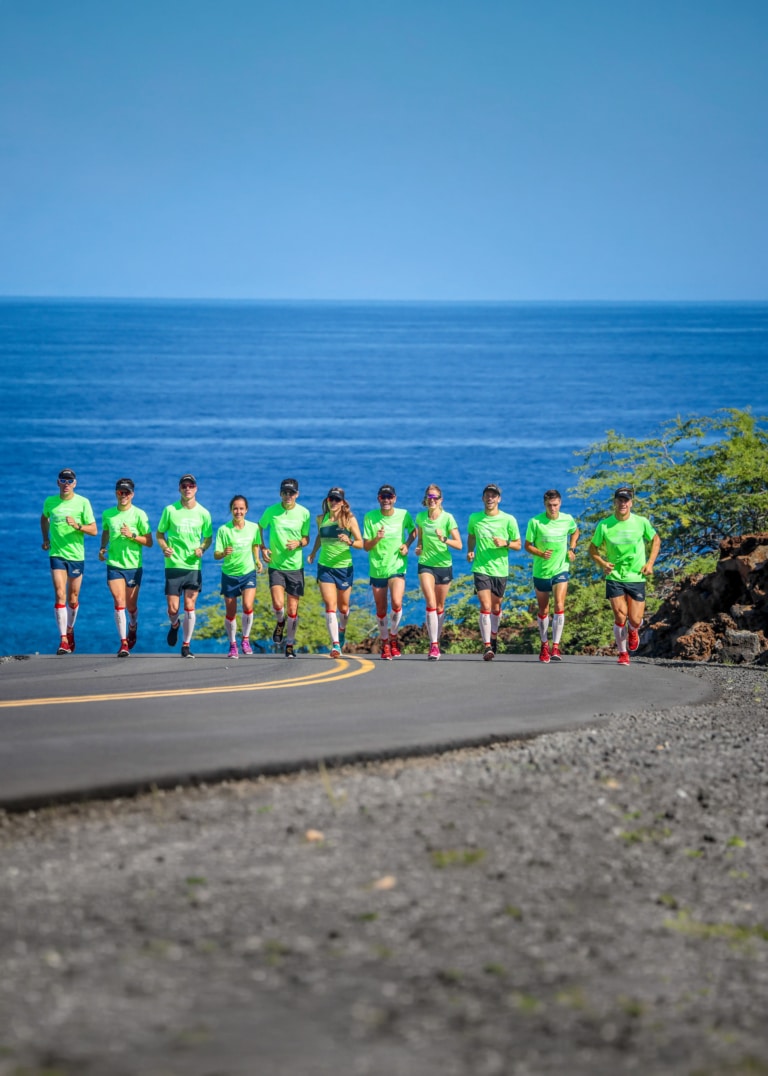 Team Argon 18 France - Groupe d'athlètes en plein entraînement de course à pied sur une route côtière lors d'un stage sportif Ironman Kona 2018