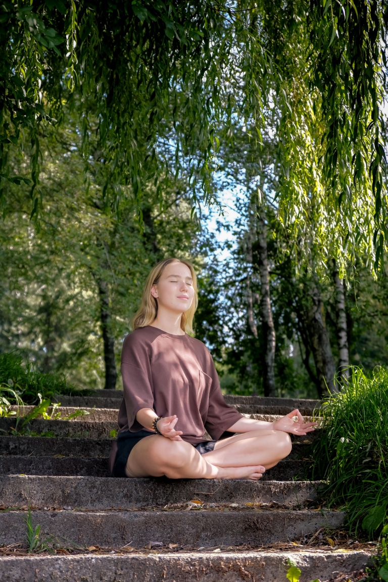 Femme pratiquant la méditation de pleine conscience et le yoga en plein air pour une séance de bien-être