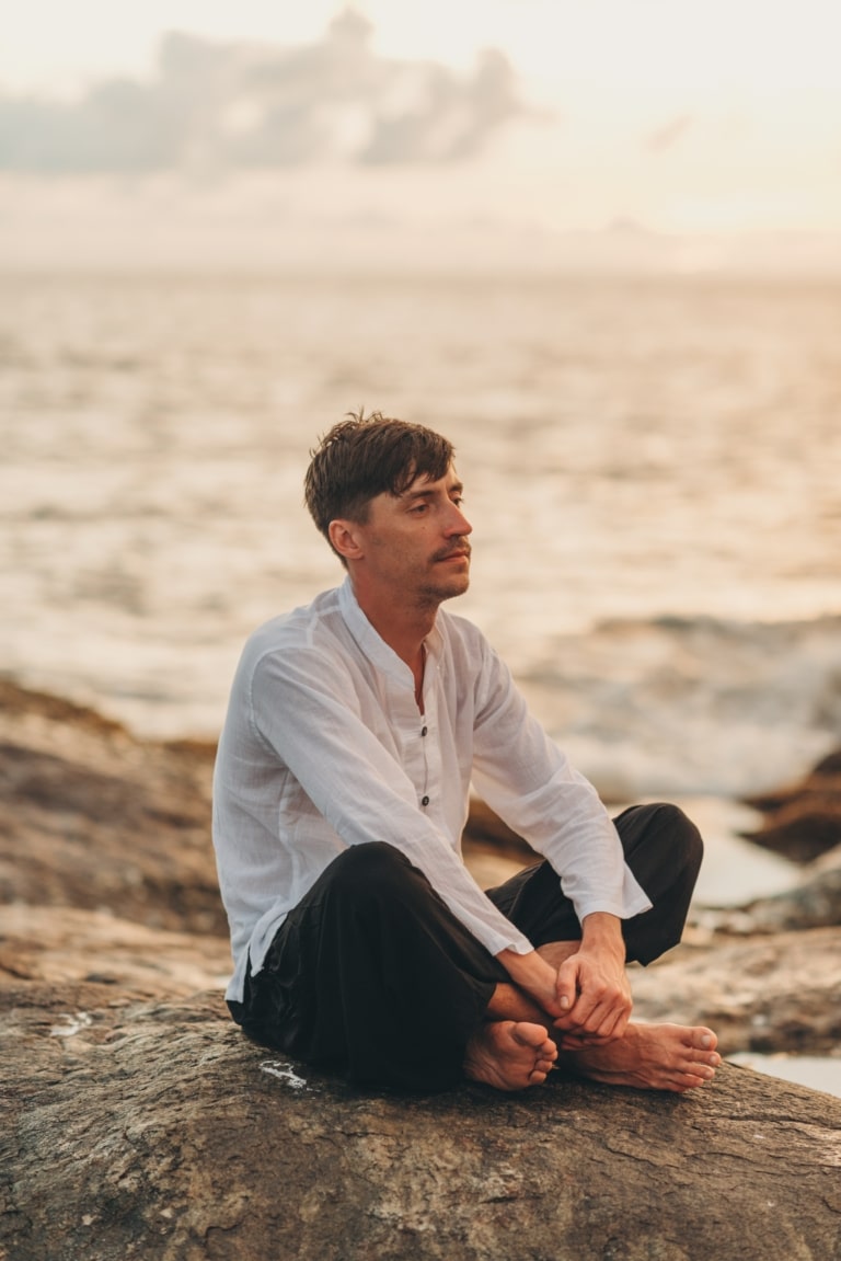 Homme pratiquant la méditation et la relaxation en pleine conscience au bord de la mer
