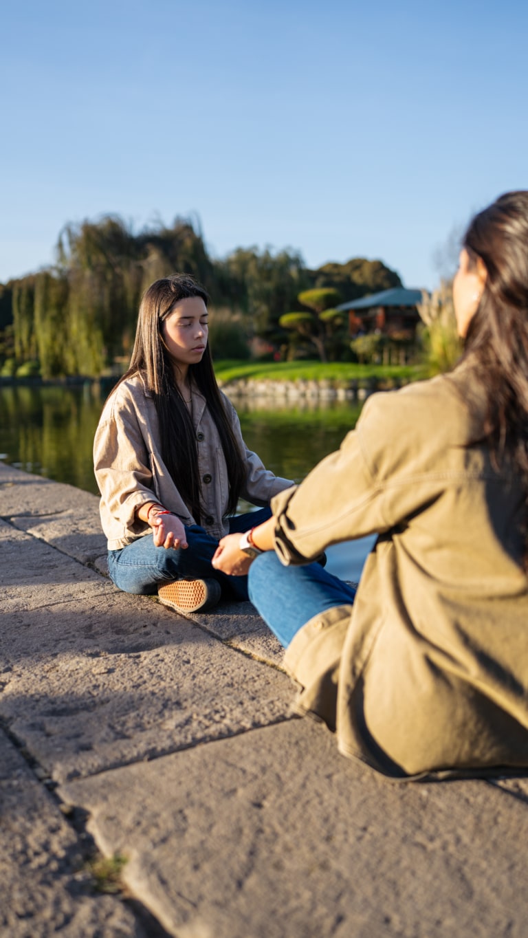 Deux femmes pratiquant la méditation de pleine conscience en plein air pour une séance de relaxation et bien-être