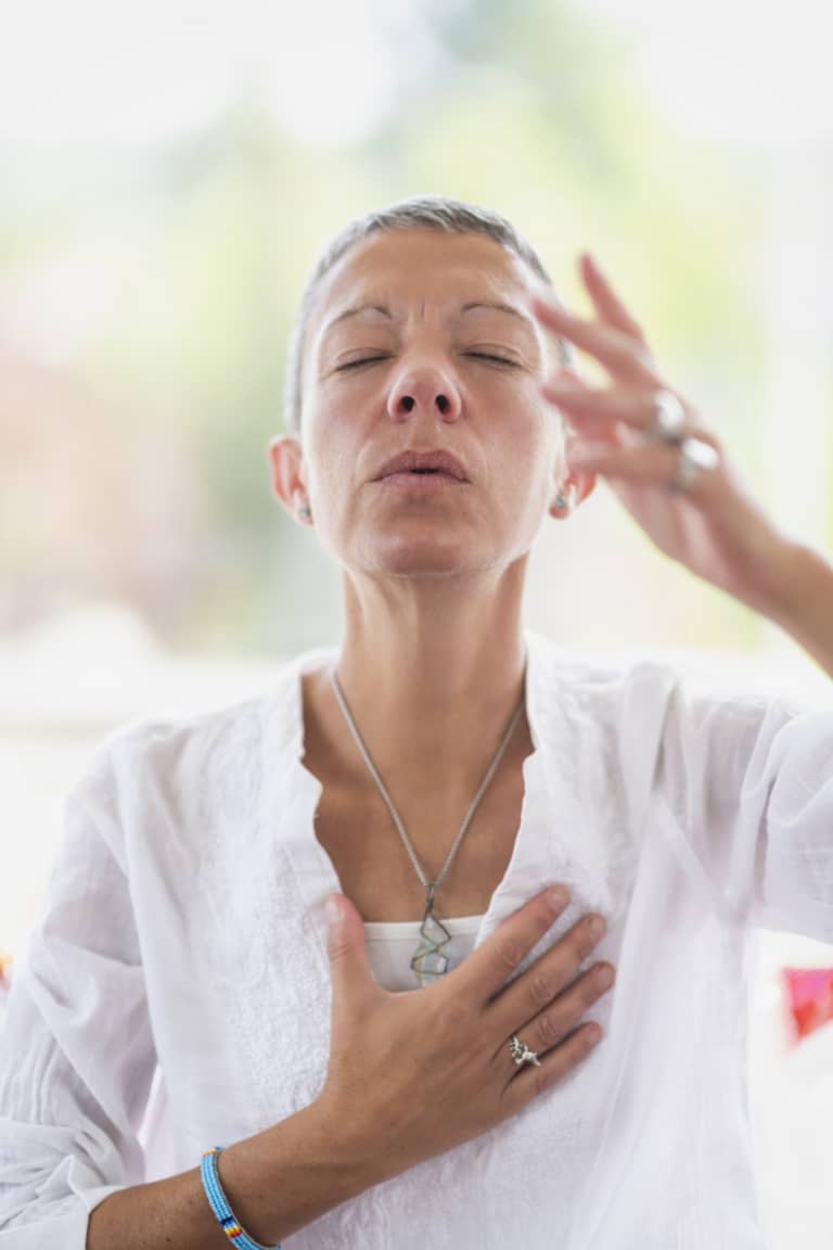 Femme pratiquant une séance de sophrologie et de méditation pour la gestion du stress et le bien-être